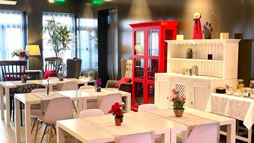 un restaurant avec des tables et des chaises blanches et une armoire rouge dans l'établissement Arc My Otel, à Ponte de Lima