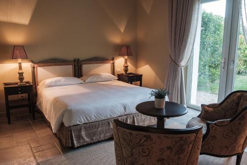 Capriva del FriuliにあるRelais Russiz Superioreのベッドルーム1室(ベッド1台、テーブル、椅子付)