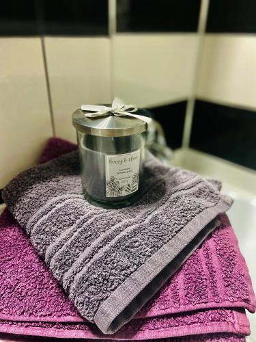 a candle sitting on top of a pink towel at Cozy Central Place in Brăila