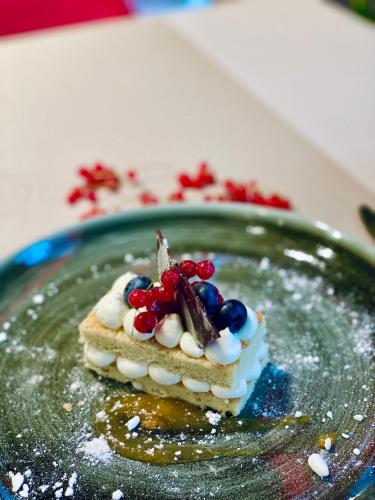 a piece of cake with fruit on a plate at Arche Hotel Krakowska in Warsaw