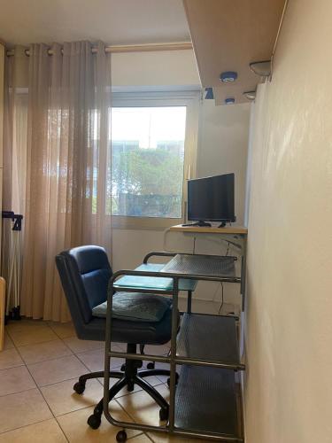 une pièce avec un bureau avec un ordinateur et une chaise dans l'établissement Résidence Le Méditerranée, à Menton