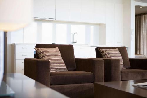 a living room with two chairs and a kitchen at Wyndham Resort Torquay in Torquay