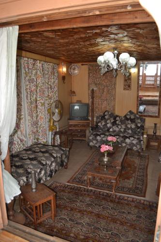 a living room with a couch and a tv at Houseboats Jackson Heights in Srinagar