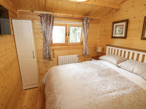 1 dormitorio con 1 cama en una habitación de madera en Port Heron Lodge, en Athlone