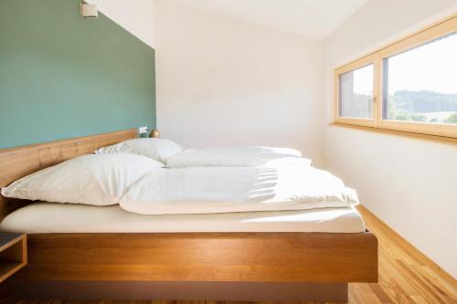 a bedroom with a bed with white sheets and a window at Ferienwohnung Elfriede in Neukirch