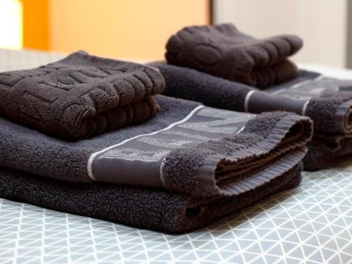 une pile de serviettes posée sur une table dans l'établissement Trankil'Apparts Gare, à Saint-Quentin