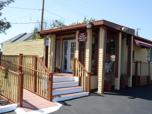 a small building with a porch and stairs at Hitching Post Studios Inn in Santa Cruz