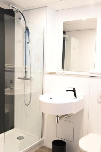 a bathroom with a sink and a shower at The Originals Boutique, Hôtel Montélimar in Montélimar