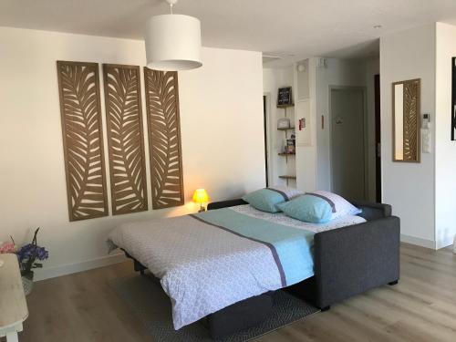 サン・メダール・アン・ジャルにあるLE LOGIS DES JALLESのベッドルーム1室(青い枕のベッド1台付)