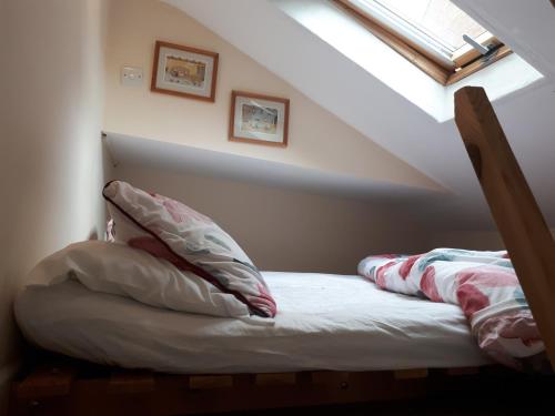 una cama con almohadas en un ático en Perfect location studio en Lewes