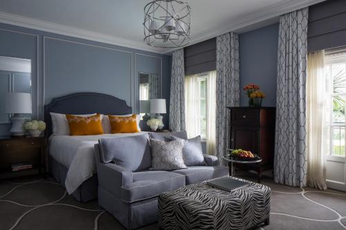 a bedroom with a bed and a chair and a couch at Four Seasons Hotel The Westcliff in Johannesburg