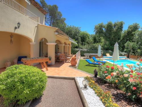 a backyard with a swimming pool and a house at Villa Bois Doré in Valbonne