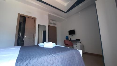 a white bedroom with a bed and a chair at WiSaRelax in Brusciano