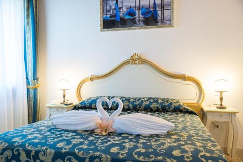 a bed with a swan shaped pillow on it at Al Mascaron Ridente in Venice