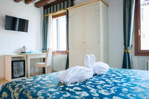 a bedroom with a bed with a blue comforter at Al Mascaron Ridente in Venice
