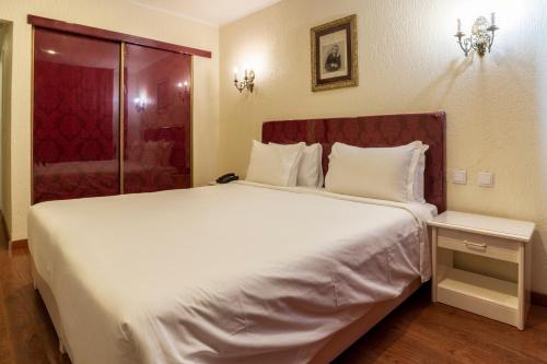 a large white bed in a hotel room at Hotel A.S. Lisboa in Lisbon