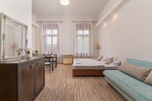 a living room with a bed and a couch at Világóra Apartman in Gyula