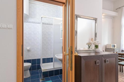 a bathroom with a sink and a toilet and a mirror at Világóra Apartman in Gyula