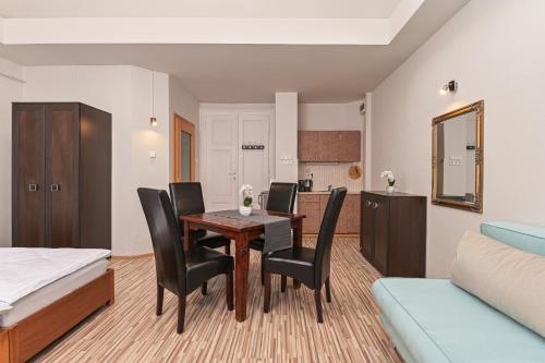 a living room with a dining room table and chairs at Világóra Apartman in Gyula