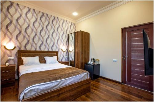 a bedroom with a large bed and a wooden door at Arma Boutique Hotel in Yerevan