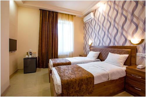 a hotel room with two beds and a window at Arma Boutique Hotel in Yerevan