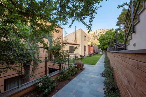 a walkway between two buildings with plants and trees at Gratteri Resort in Gratteri