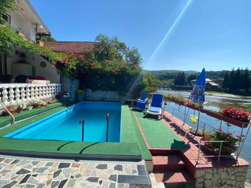 a swimming pool with a view of a river at Villa Dino in Kulen Vakuf