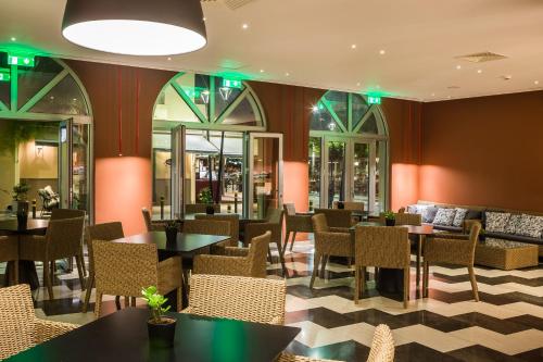 a restaurant with tables and chairs and green lights at Aenos Hotel in Argostoli