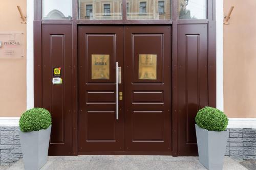 a pair of brown doors in front of a building at Renome Hotel in Saint Petersburg