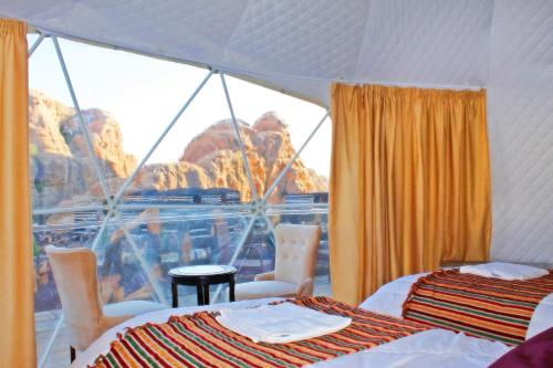 a room with two beds and a view of the mountain at Seven Wonders Luxury Camp in Wadi Musa