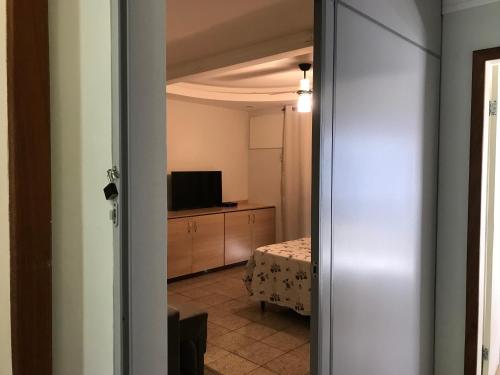 Zimmer mit Blick auf ein Bett und einen TV in der Unterkunft Bento Ferreira Hostel in Vitória