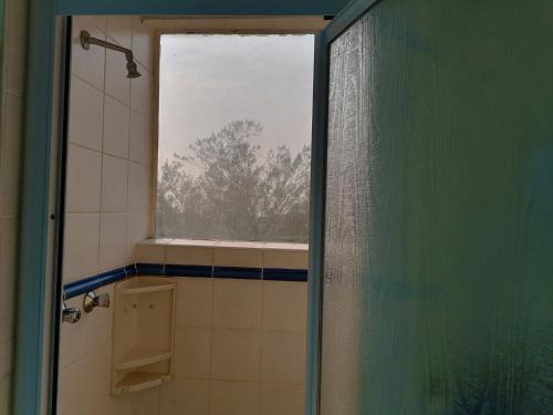 a bathroom with a window and a shower with a shower curtain at Boathouse Bed and Biscuit - Upper Deck in Ramsgate