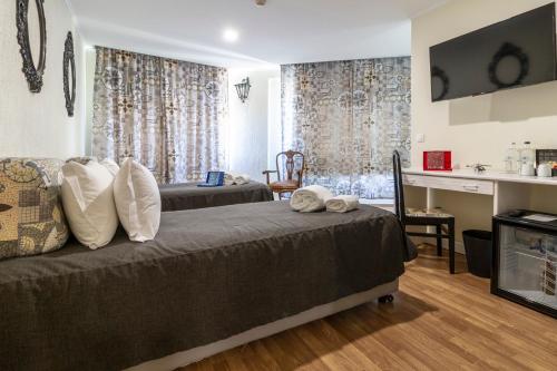 a bedroom with two beds and a desk in it at Hotel A.S. Lisboa in Lisbon
