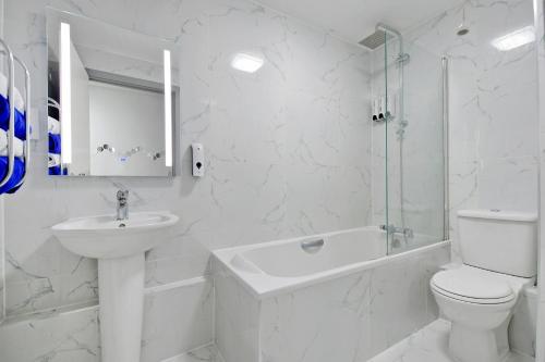 a white bathroom with a toilet and a sink at Sheffield Penthouse with Rooftop Terrace & FREE Parking in Sheffield