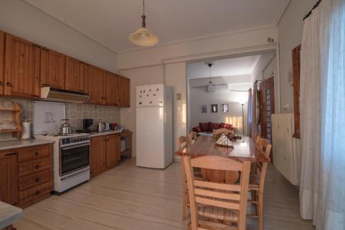 a kitchen with a table and chairs and a refrigerator at KERASIA'S COUNTRY HOUSE in Volos