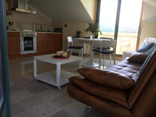 a living room with a couch and a table at Ático luminoso en O Rosal in Rosal