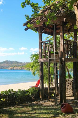 a wooden hut on the beach near the water at Club Punta Fuego in Nasugbu