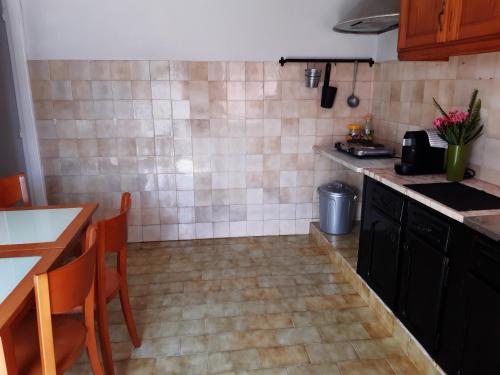 ヴィアナ・ド・カステロにあるQuiet 1 bed house with kitchen Viana do Casteloのキッチン(カウンター、テーブル、椅子付)
