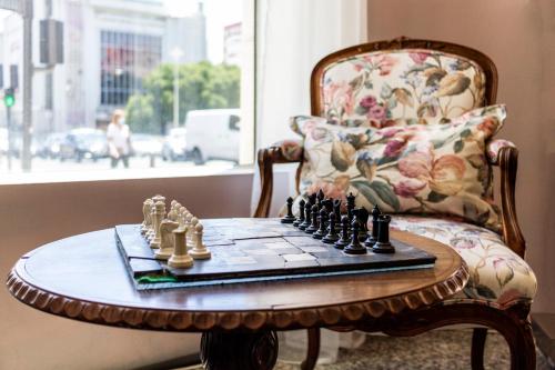 a chess board on a table in front of a chair at Hotel A.S. Lisboa in Lisbon