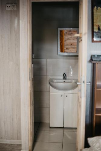 a bathroom with a white sink and a mirror at Domki-Temar Kompleks Wypoczynkowy in Dąbie