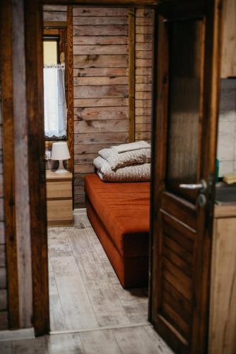 a room with a bed with two towels on it at Domki-Temar Kompleks Wypoczynkowy in Dąbie