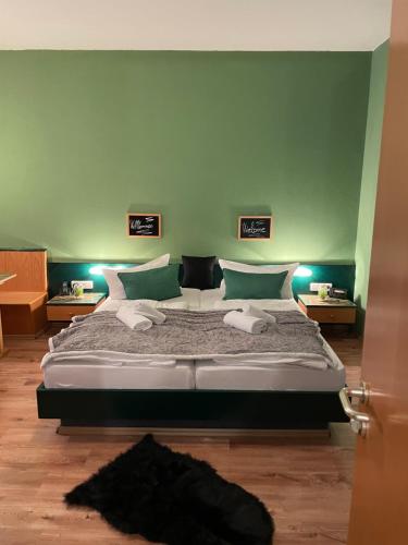 a bedroom with a large bed with green walls at Berghotel Drei Brüder Höhe in Marienberg