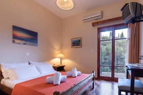 a bedroom with a large bed and a window at Balis Apartments in Paleokastritsa
