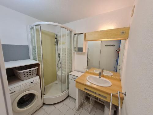 une salle de bain avec un lavabo et une machine à laver dans l'établissement Sète - Confortable appartement T3 climatisé 6 personnes avec garage - 150 m de la plage, à Sète