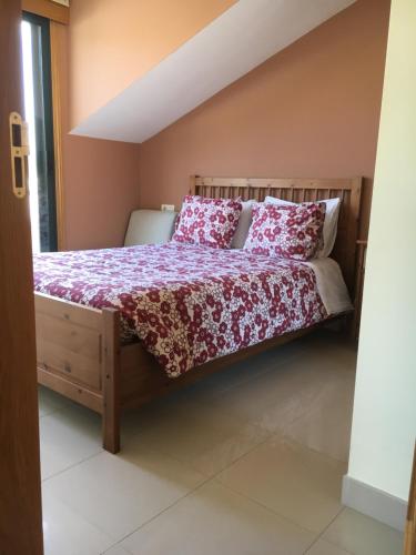una camera con letto con lenzuola rosse e bianche di Ático luminoso en O Rosal a Rosal