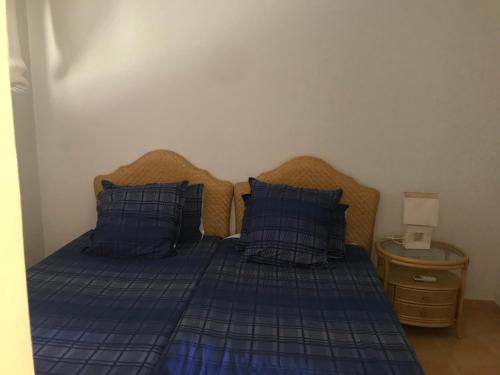 a bedroom with a blue bed with blue pillows at Meloneras in Meloneras