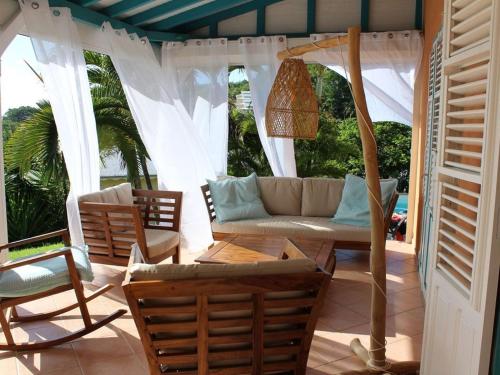 a porch with a couch and a table and chairs at Villa Casalane in Quartiers Anse à lʼÂne