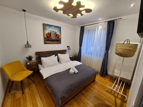 a bedroom with a bed and a yellow chair at Old Bakery House in Sinaia
