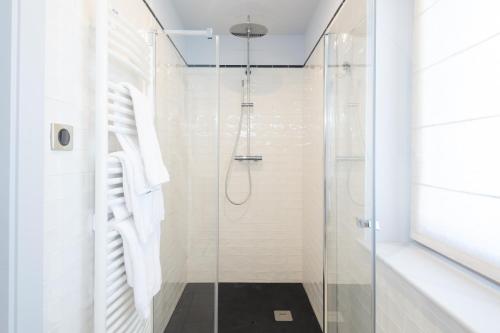a shower with a glass door in a bathroom at Le Manoir Au Lac in Gérardmer