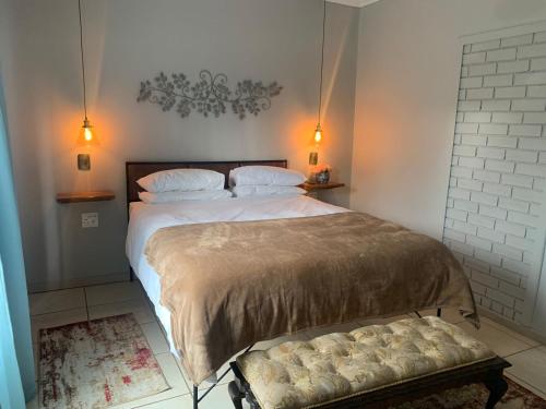 1 dormitorio con cama y banco. en Douglas Villas, en Tzaneen